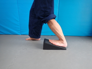 Wade dehnen – Schollenmuskel (Musculus soleus): Die Ausgangsstellung ist gleich wie bei der Übung für den Zwillingswadenmuskel. Allerdings verlagern wir nun das Gewicht auf das zu dehnende Bein und knicken mit dem Knie ab.